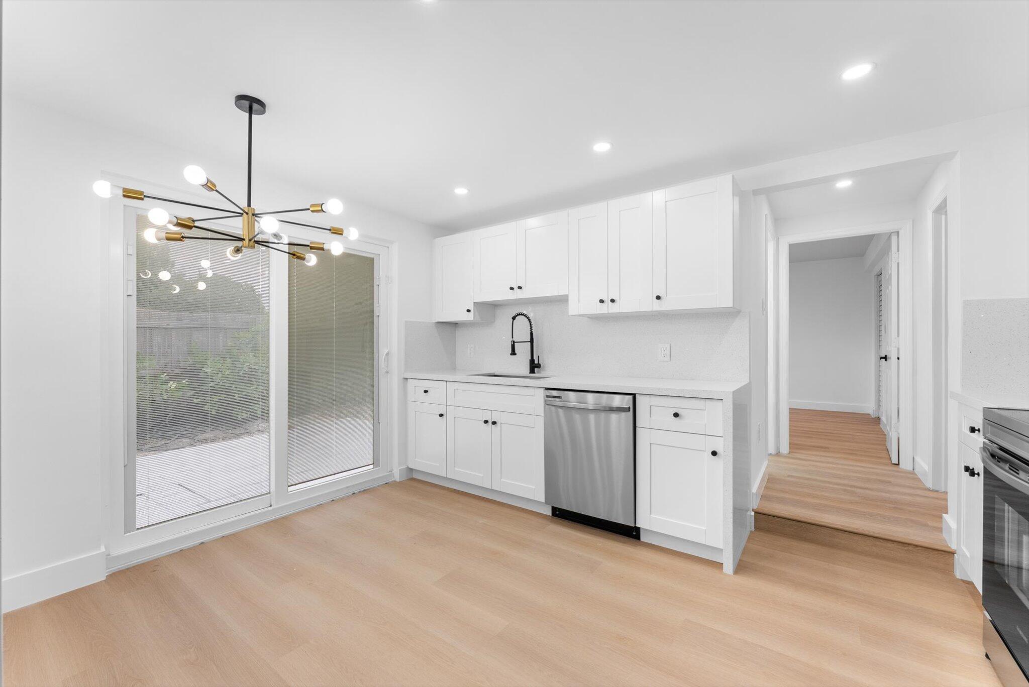 1891 Ridge Road North Palm Beach, FL 33408 - Photo 5 of 24 a kitchen with white cabinets and sink