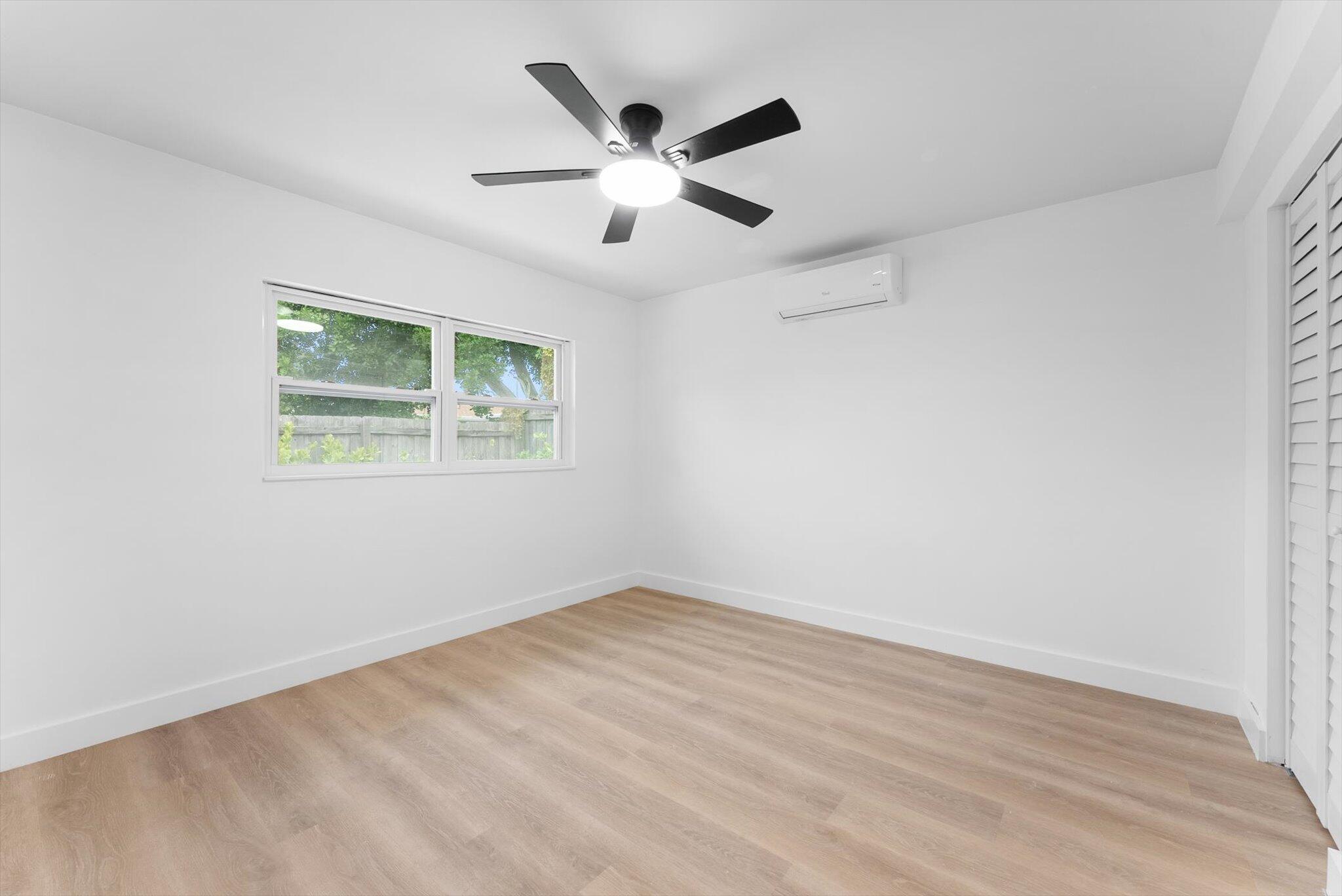 1891 Ridge Road North Palm Beach, FL 33408 - Photo 10 of 24 an empty room with wooden floor ceiling fan and windows