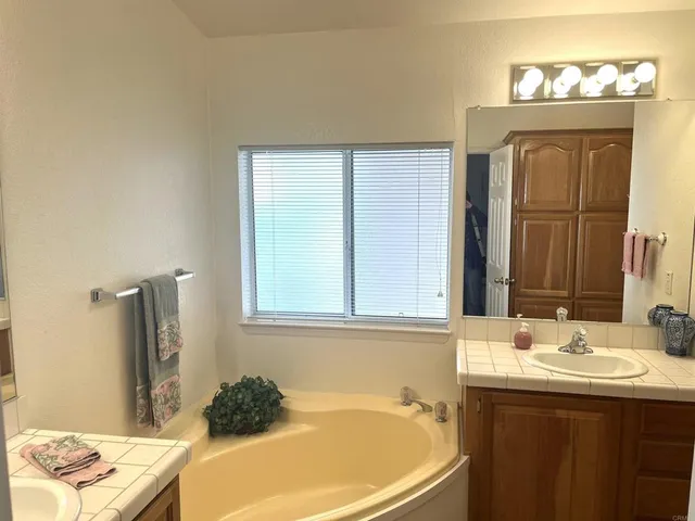 a bathroom with a tub sink and a mirror