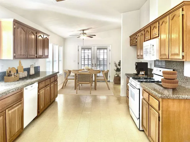 a kitchen with stainless steel appliances granite countertop a stove a sink and a microwave