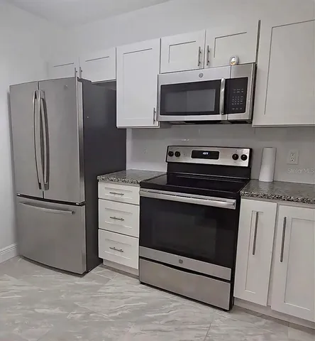 a kitchen with stainless steel appliances a stove a microwave and a refrigerator