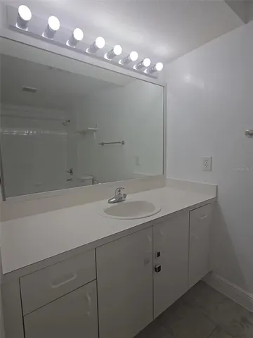 a bathroom with a sink vanity and mirror