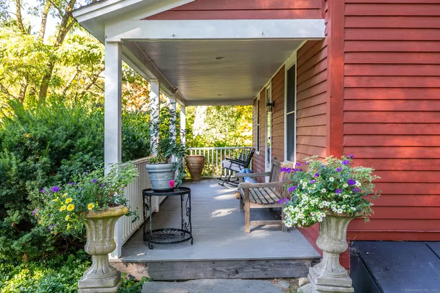 a view of a porch with chairs and potted plants