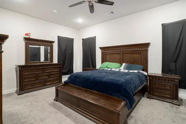 a bedroom with a bed and a flat tv screen on wall