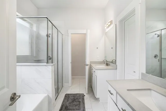 a bathroom with a tub sink vanity and mirror