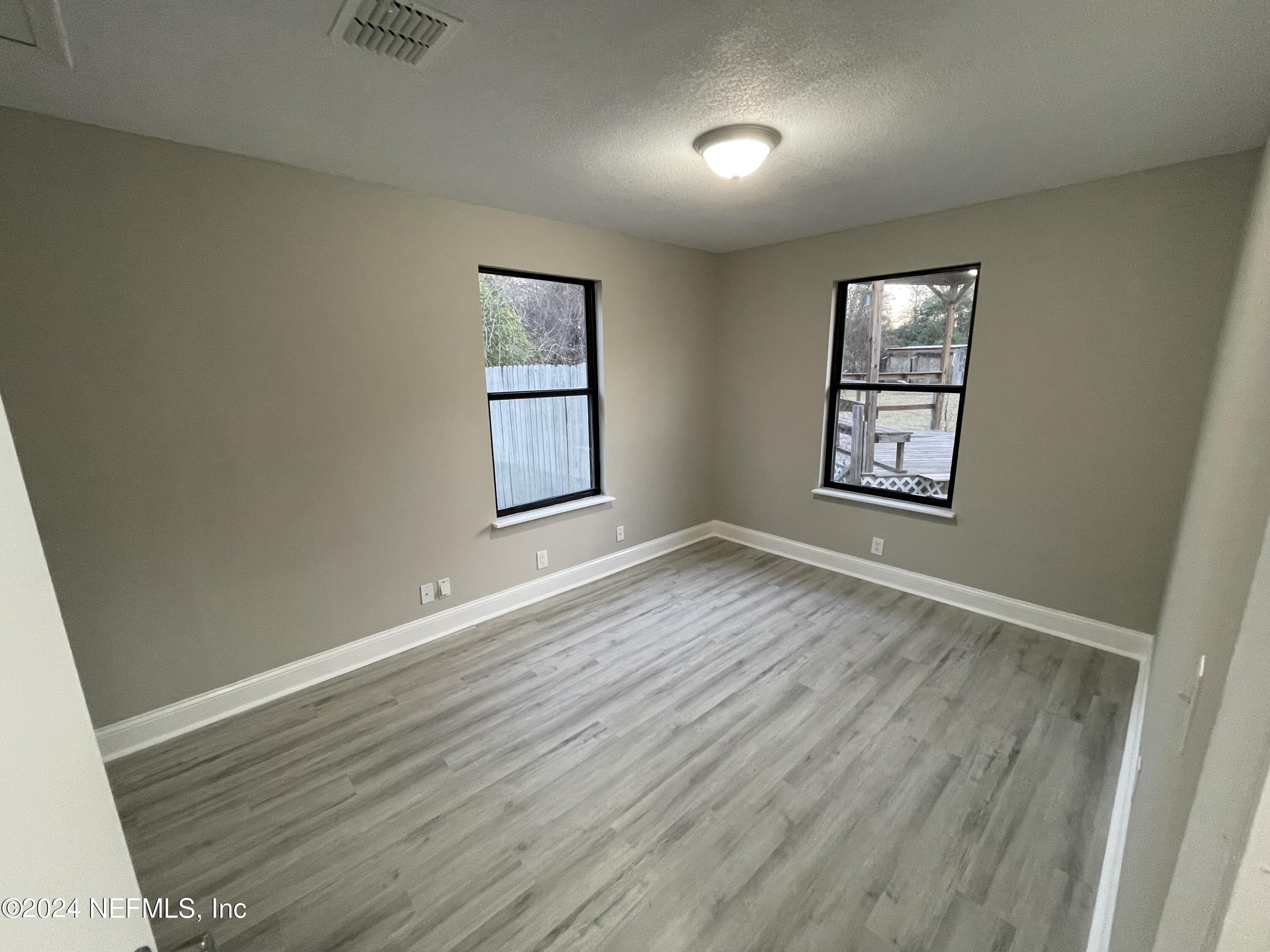 4535 Chipmunk Road Middleburg, FL 32068 - Photo 19 of 26 an empty room with wooden floor and windows