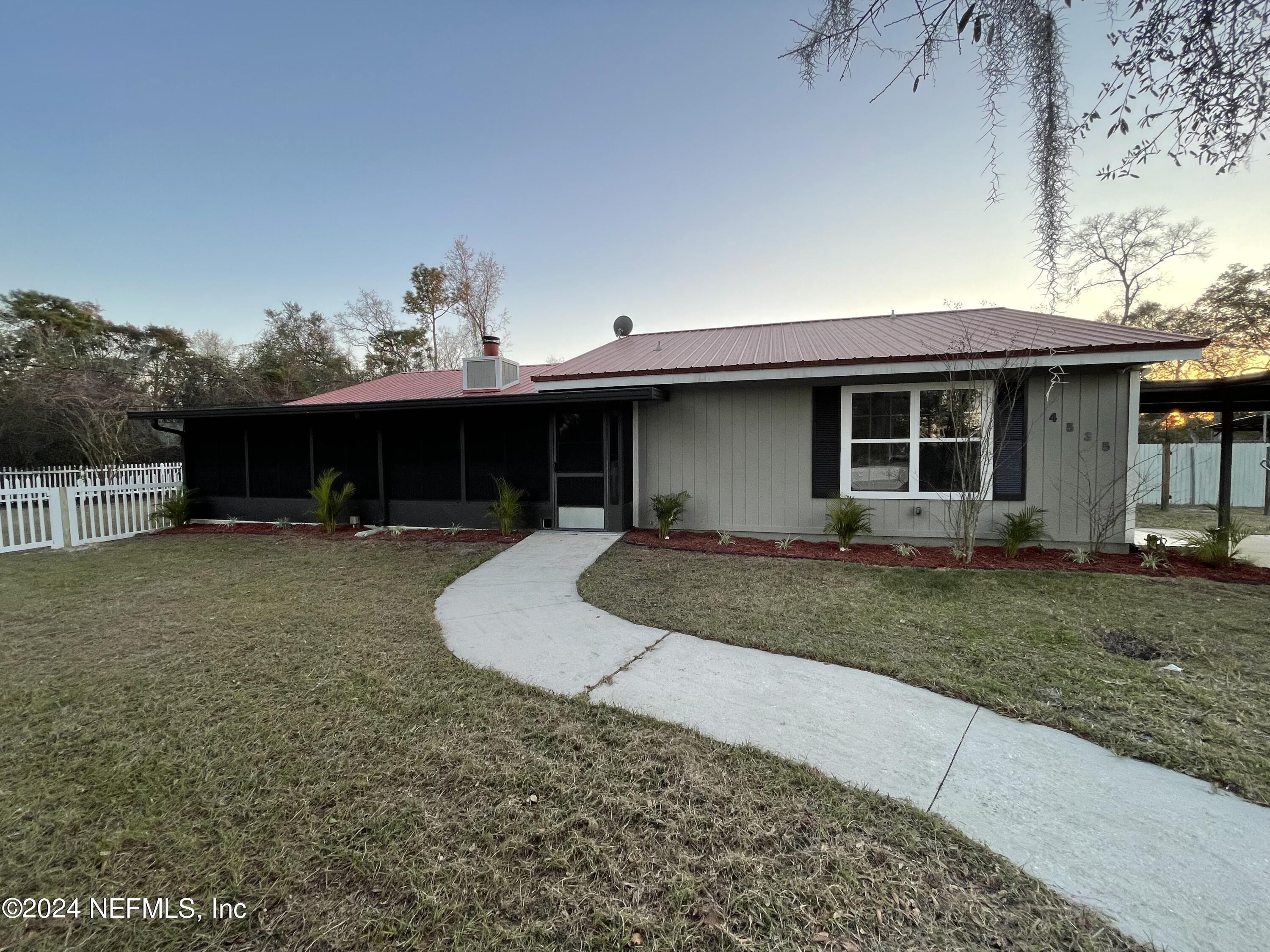 4535 Chipmunk Road Middleburg, FL 32068 - Photo 6 of 26 a front view of a house with a yard and garage