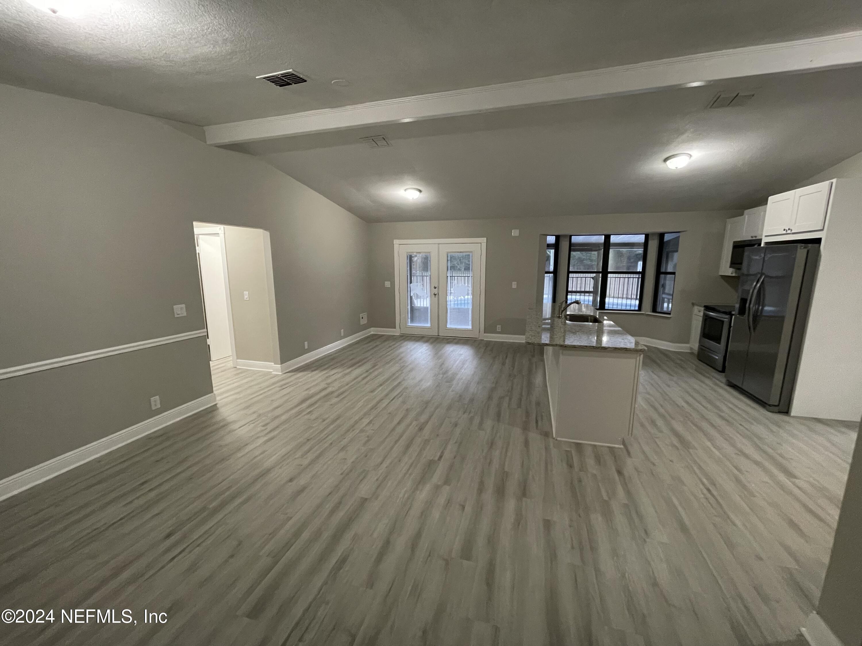 4535 Chipmunk Road Middleburg, FL 32068 - Photo 7 of 26 a view of a room with wooden floor and a kitchen
