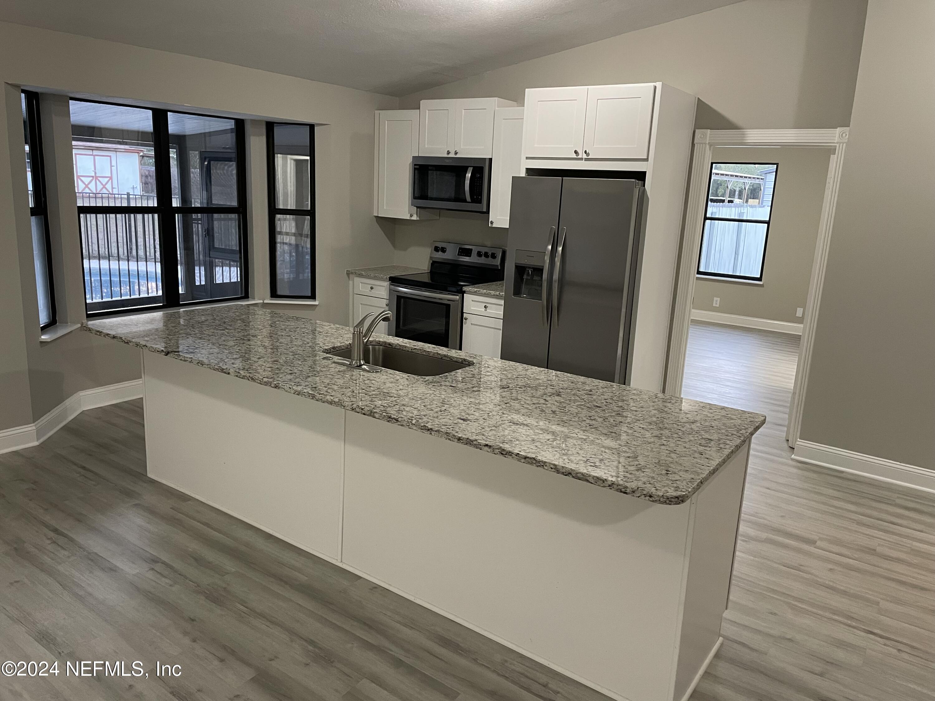 4535 Chipmunk Road Middleburg, FL 32068 - Photo 9 of 26 a kitchen with granite countertop a refrigerator and a sink