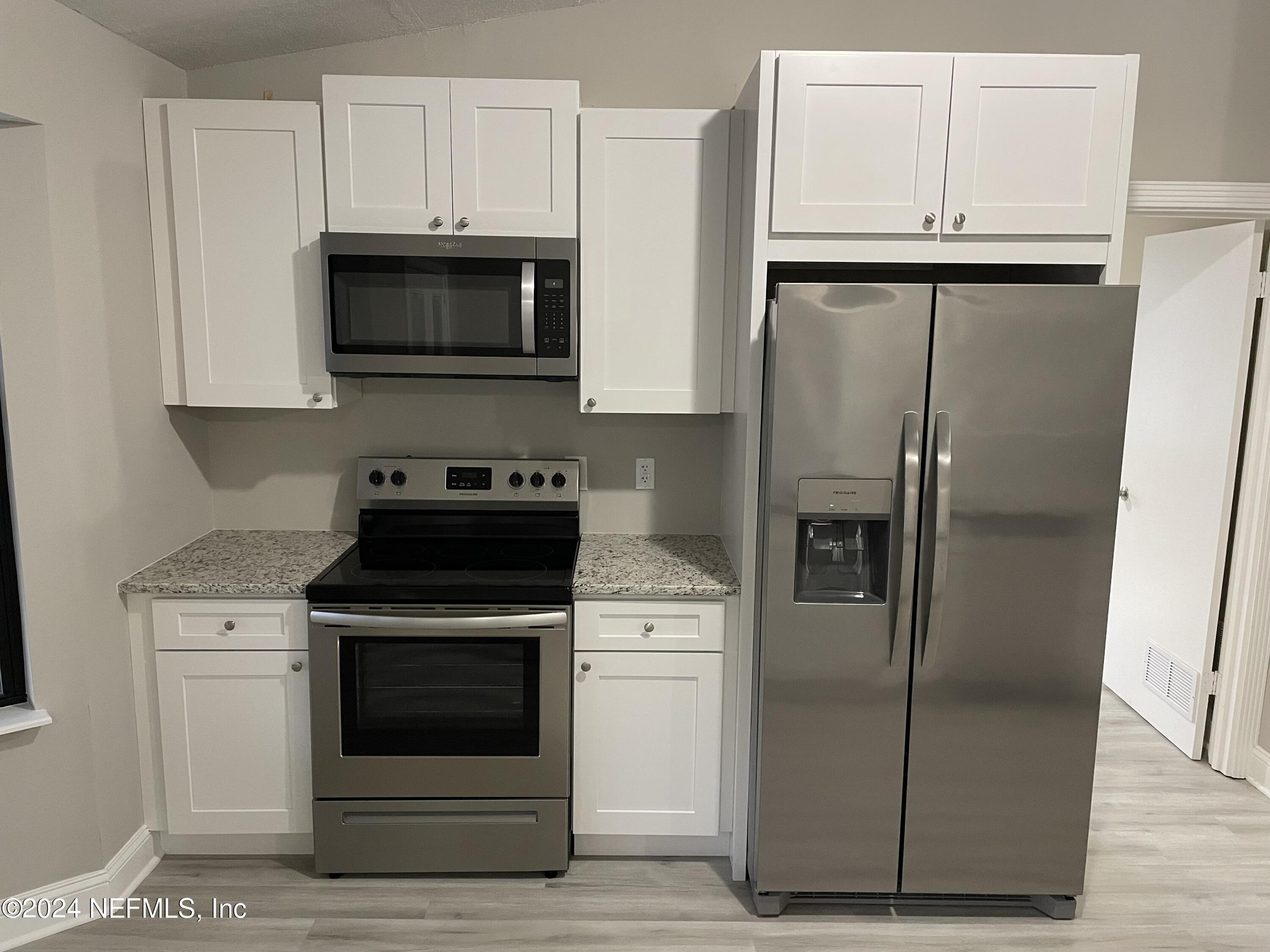4535 Chipmunk Road Middleburg, FL 32068 - Photo 10 of 26 a kitchen with white cabinets and stainless steel appliances