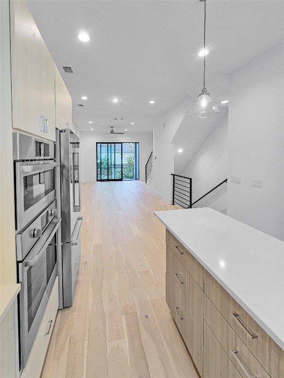 3807 Threadgill Street Austin, TX 78723 - Photo 35 of 36 a kitchen with stainless steel appliances a refrigerator and a wooden floor