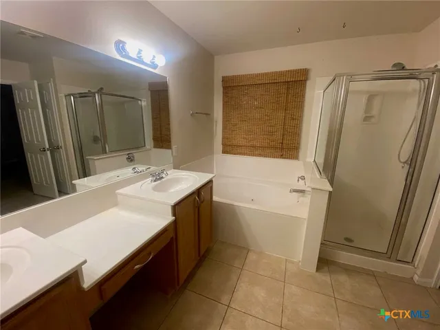 a bathroom with a tub sink and mirror