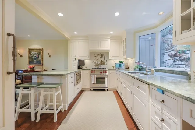 a large kitchen with stainless steel appliances kitchen island granite countertop a large counter top and white cabinets