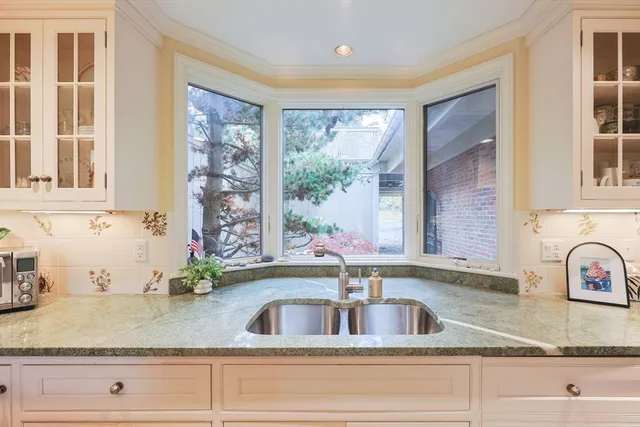 a kitchen with sink window and cabinets