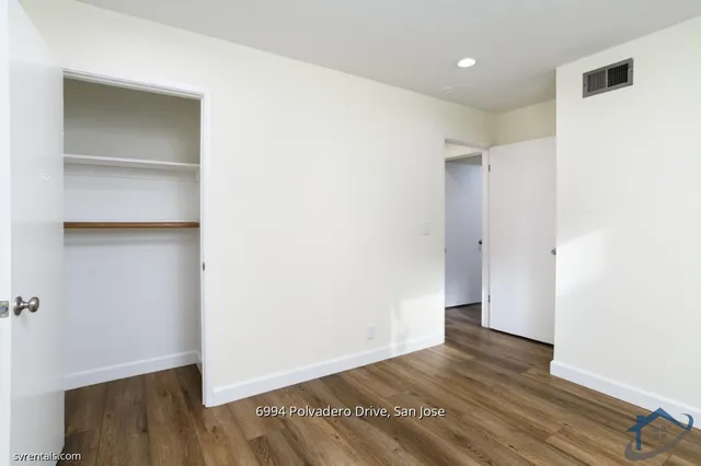 a view of an empty room with wooden floor