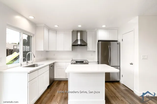 a kitchen that has a sink a counter top stainless steel appliances and cabinets