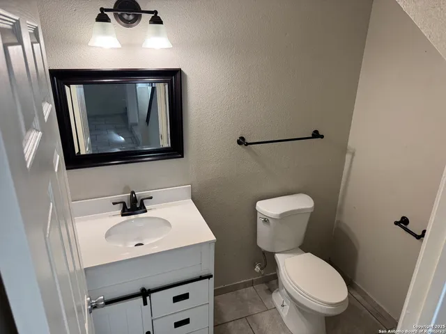 a bathroom with a toilet a sink and mirror