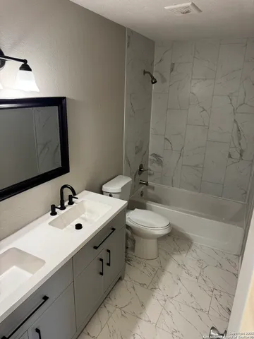 a bathroom with a sink toilet and shower