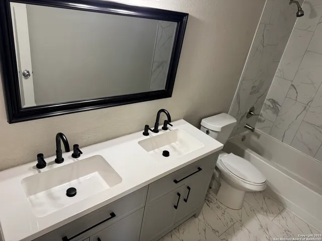 a bathroom with a sink toilet and mirror