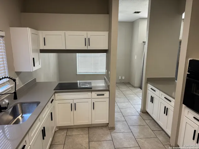 a kitchen with a stove sink and cabinets