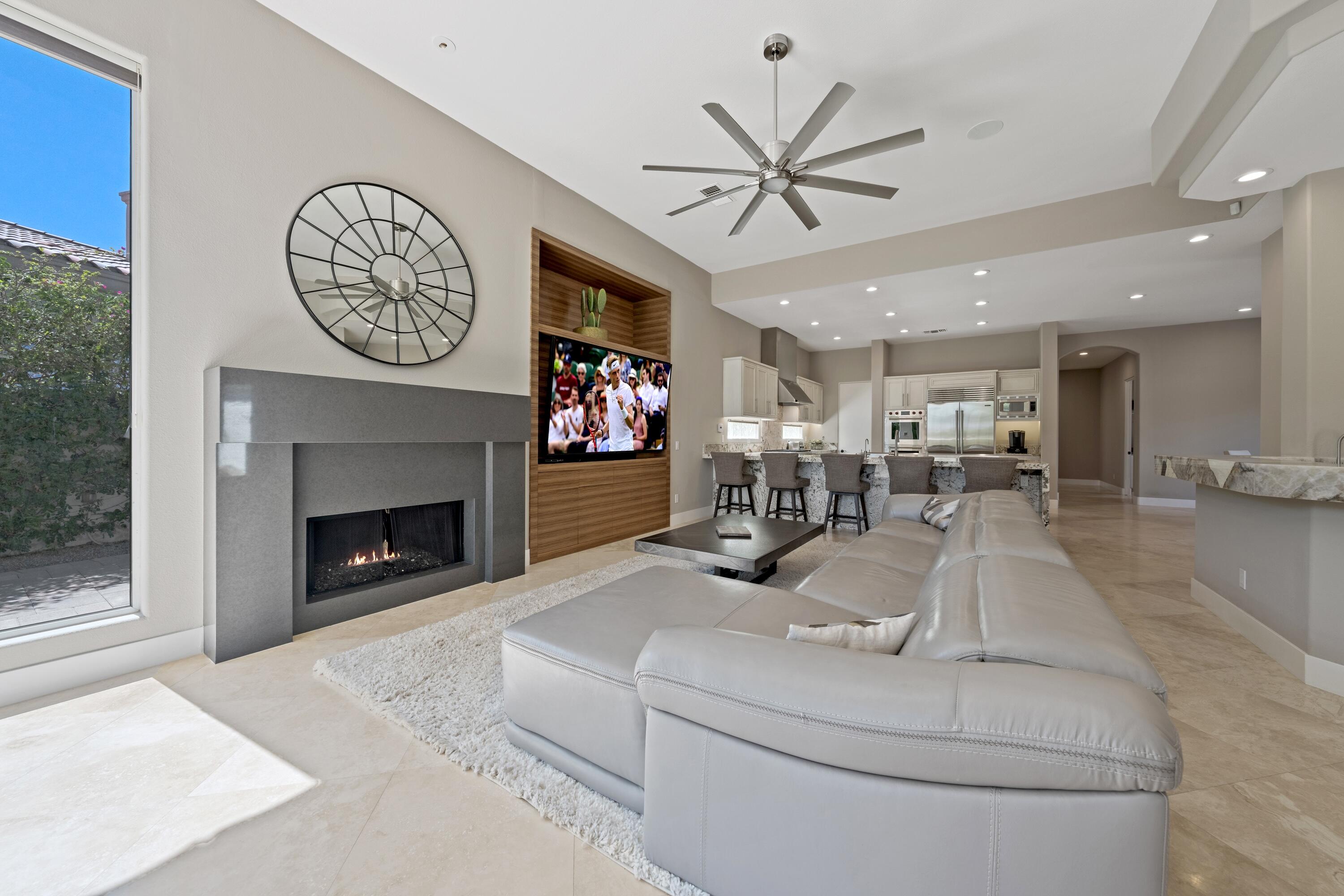 306 Loch Lomond Road Rancho Mirage, CA 92270 - Photo 14 of 60 a living room with furniture a clock and a fireplace