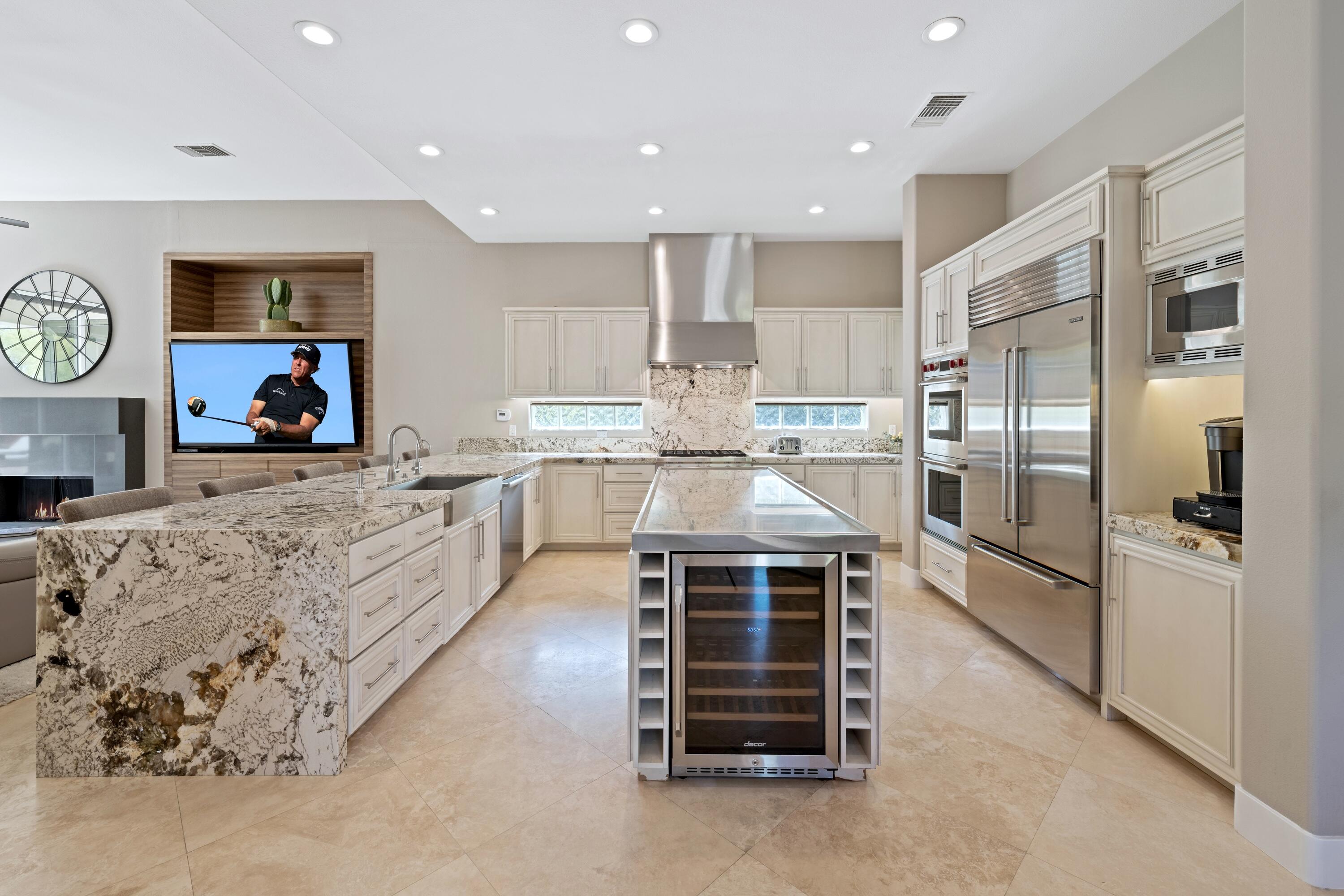 306 Loch Lomond Road Rancho Mirage, CA 92270 - Photo 18 of 60 a kitchen with stainless steel appliances kitchen island granite countertop a refrigerator and a stove top oven
