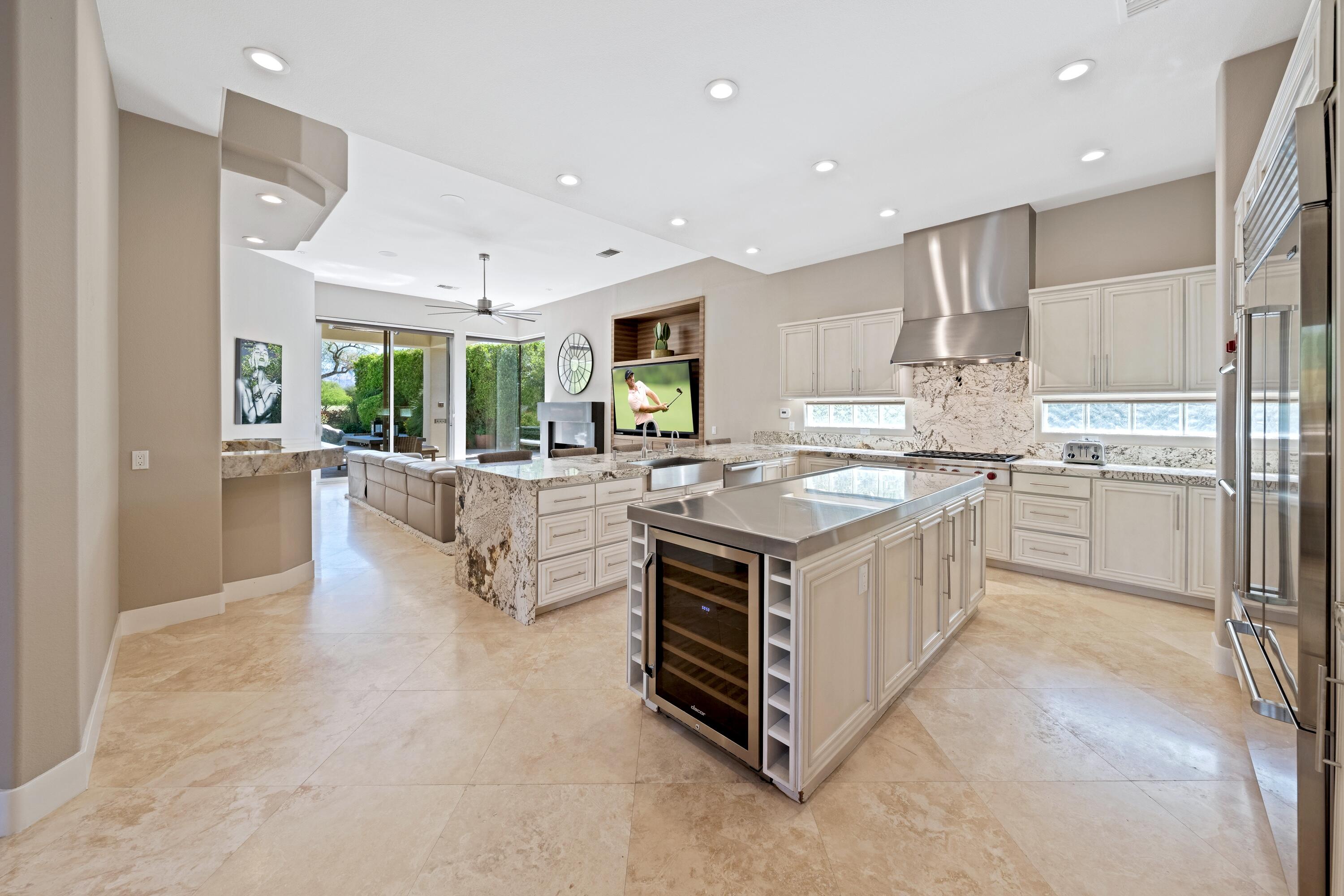 306 Loch Lomond Road Rancho Mirage, CA 92270 - Photo 19 of 60 a kitchen with stainless steel appliances a sink a stove a refrigerator cabinets and living room view