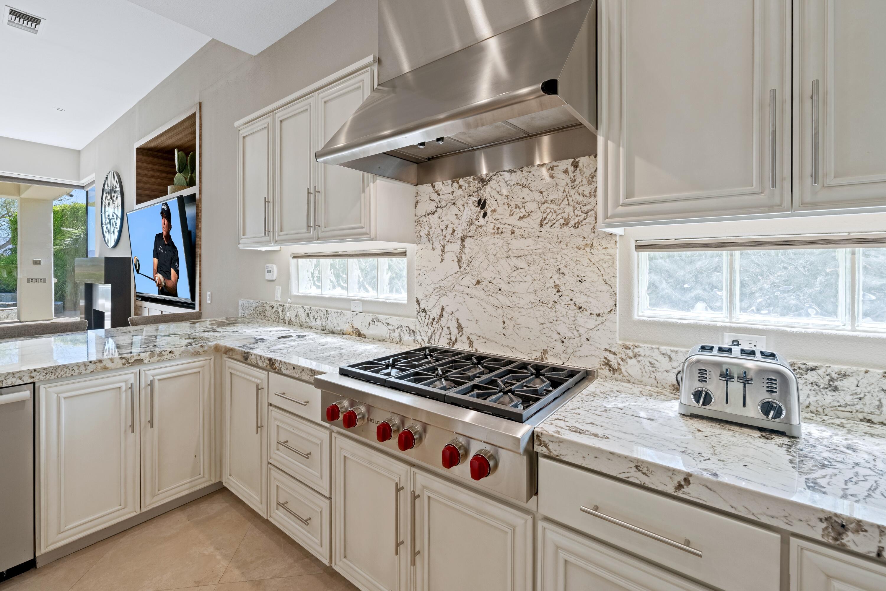 306 Loch Lomond Road Rancho Mirage, CA 92270 - Photo 20 of 60 a kitchen with granite countertop a sink stove and cabinets