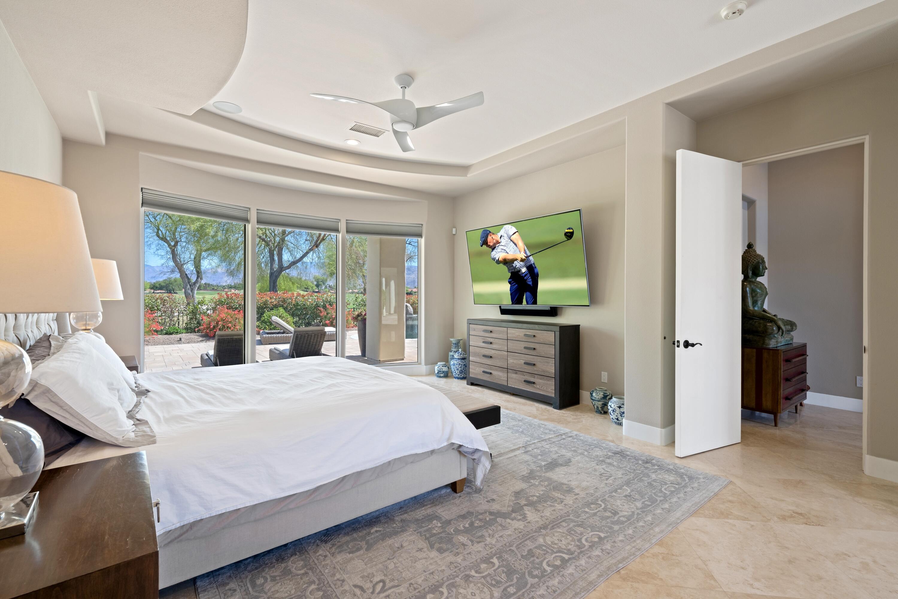 306 Loch Lomond Road Rancho Mirage, CA 92270 - Photo 26 of 60 a bedroom with a bed flat screen tv and a large window