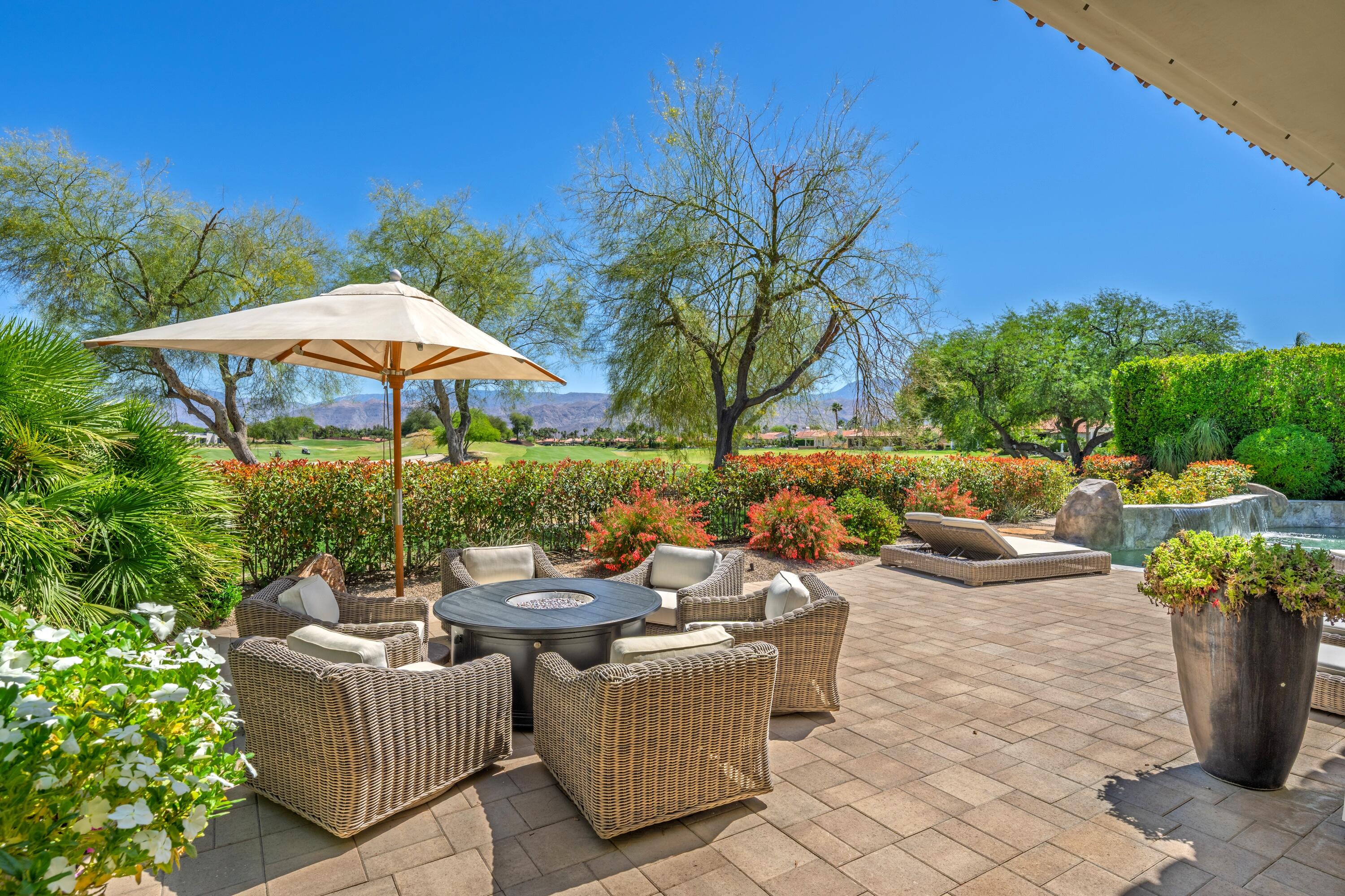 306 Loch Lomond Road Rancho Mirage, CA 92270 - Photo 3 of 60 a view of a patio with couches and table and chairs under an umbrella