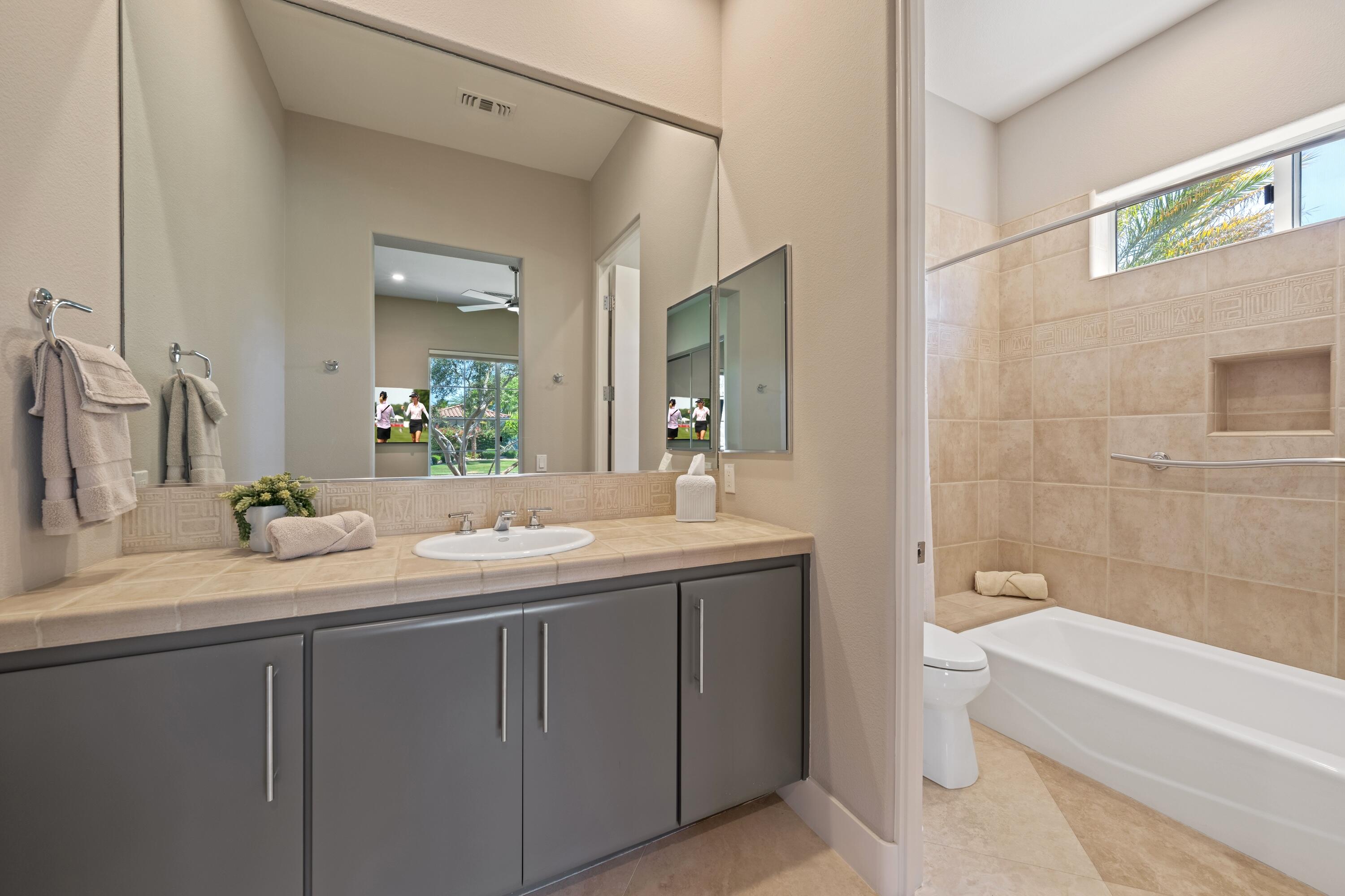 306 Loch Lomond Road Rancho Mirage, CA 92270 - Photo 35 of 60 a bathroom with a granite countertop sink double mirror and a bathtub