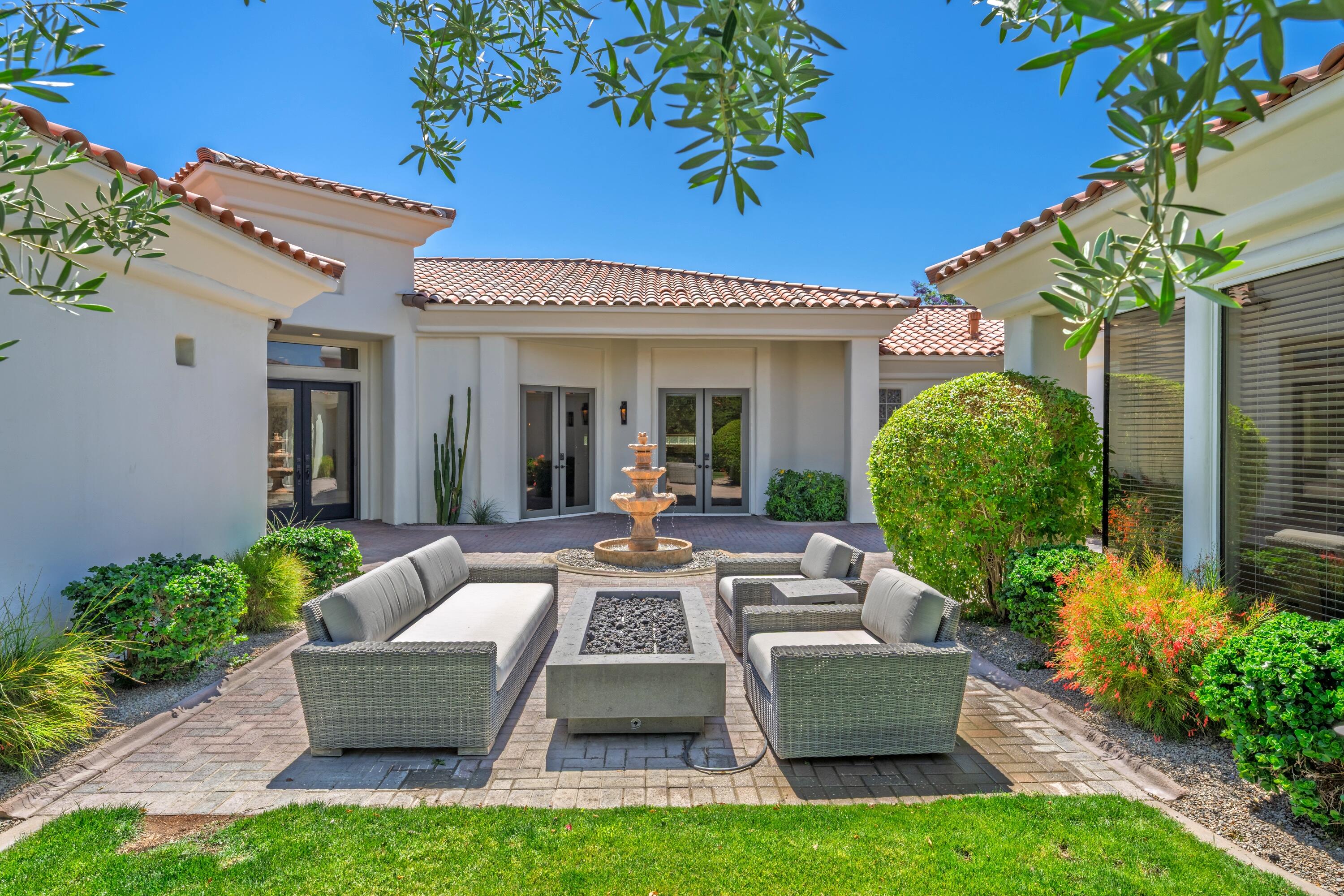 306 Loch Lomond Road Rancho Mirage, CA 92270 - Photo 7 of 60 a view of a patio with couches table and chairs potted plants and floor to ceiling window and potted plants