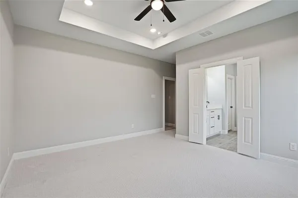 an empty room with chandelier fan