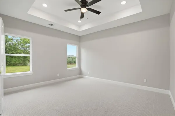 an empty room with a window and a fan