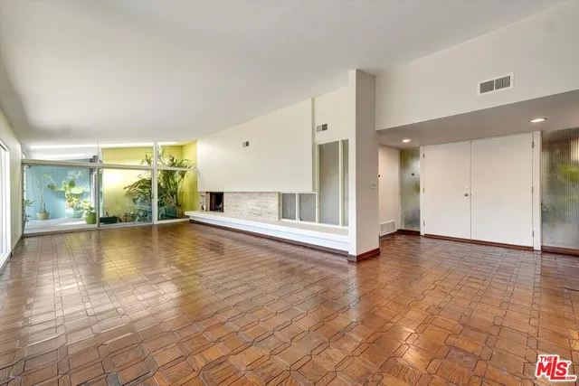 a view of an empty room with window and a fireplace