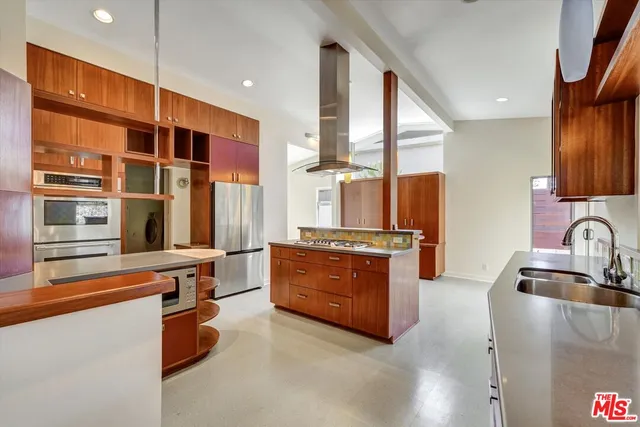 a kitchen with stainless steel appliances granite countertop a refrigerator and a stove top oven