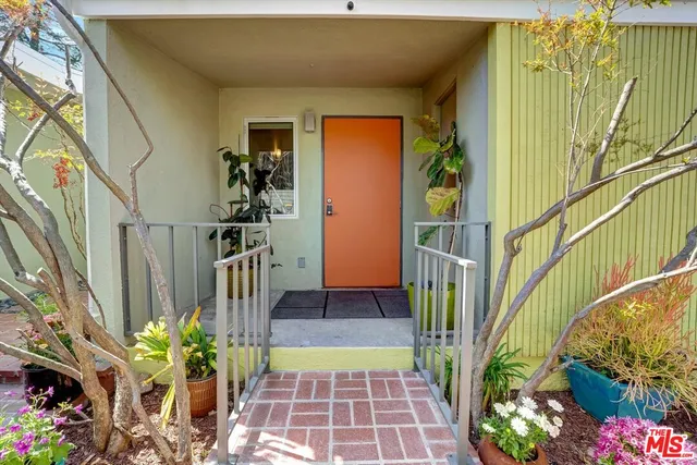 a view of a hallway with wooden floor and a living room