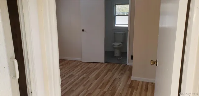 a view of a hallway with wooden floor and a door