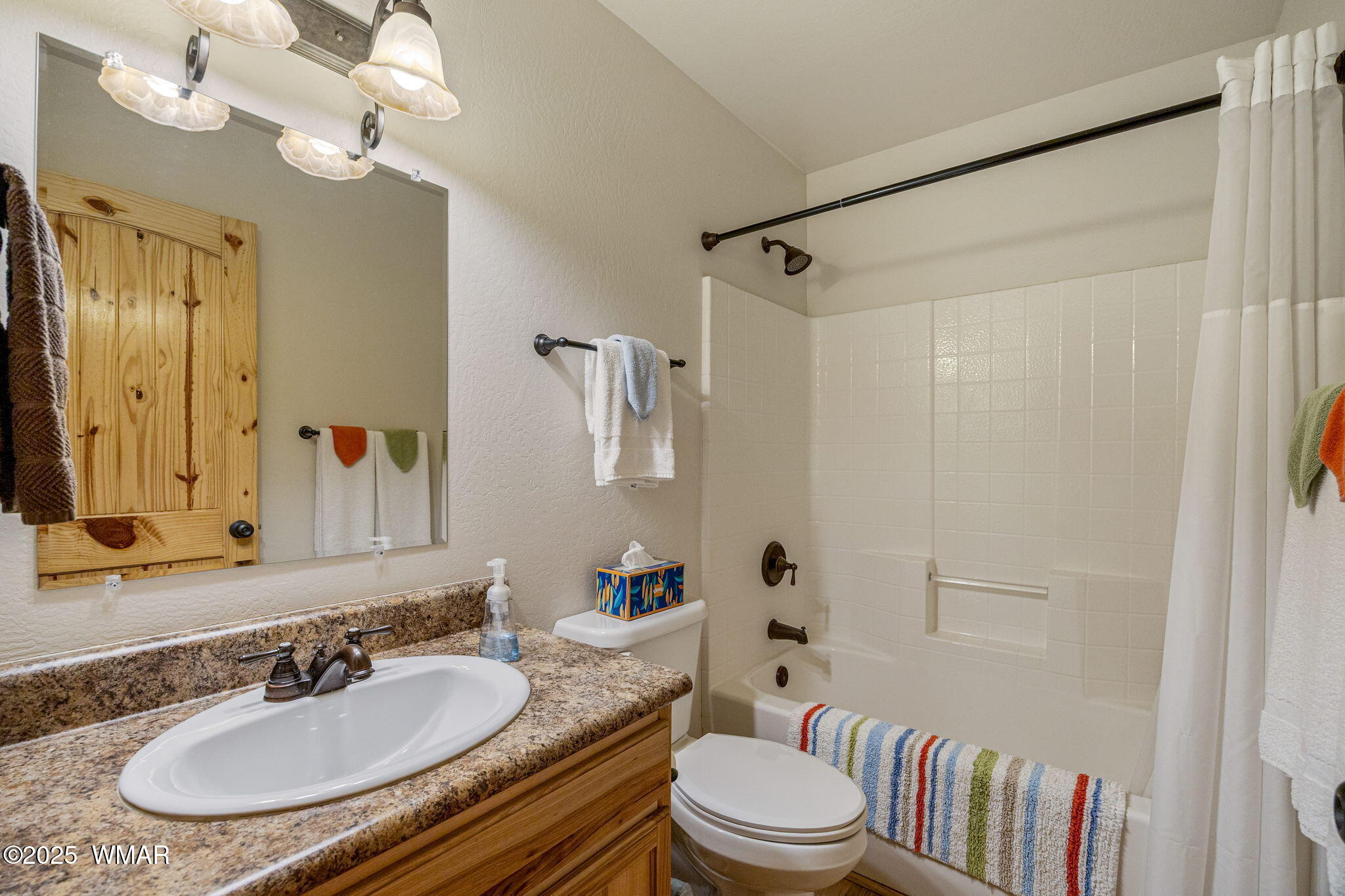 3142 Ranch Road Overgaard, AZ 85933 - Photo 19 of 35 a bathroom with a granite countertop sink toilet a large mirror and shower