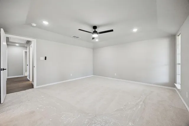 wooden floor in an empty room with a ceiling fan