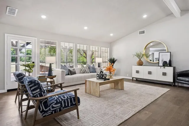 a living room with furniture and floor to ceiling windows