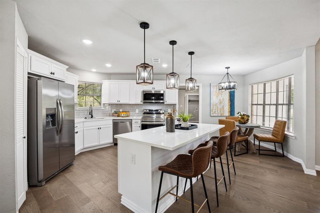 10 Chisholm Trail Lucas, TX 75002 - Photo 7 of 40 a kitchen with stainless steel appliances kitchen island granite countertop a table chairs stove and refrigerator