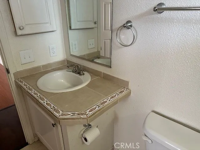 a bathroom with a granite countertop sink a mirror and shower