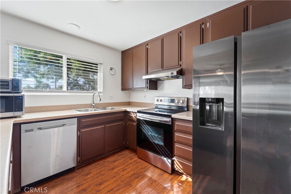 811 Cinnamon Lane Duarte, CA 91010 - Photo 12 of 22 a kitchen with stainless steel appliances granite countertop a refrigerator a sink dishwasher a stove and white countertops with wooden floor