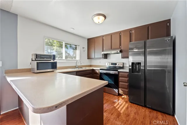 a kitchen with a appliances a sink and a refrigerator