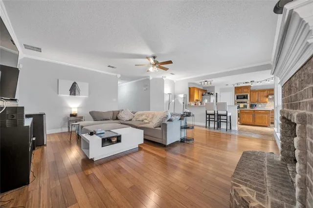 a living room with furniture and a wooden floor