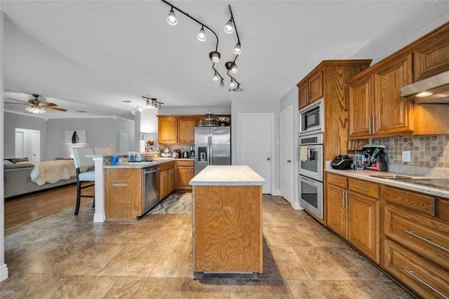 a large white kitchen with wooden floor and a sink