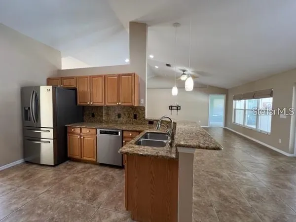 a kitchen with a refrigerator a stove a sink and a oven