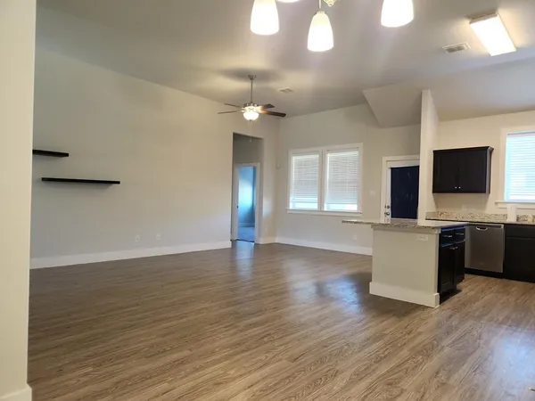 a view of a kitchen with a flat screen tv and wooden floor