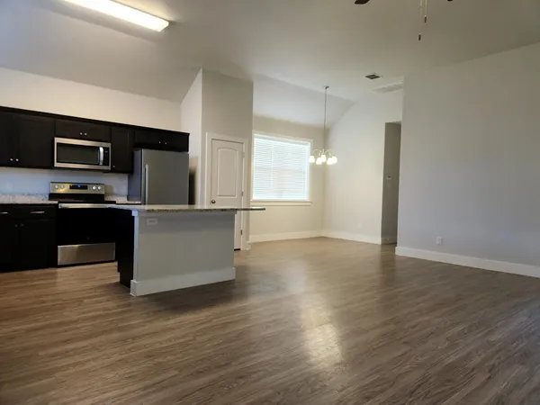 a kitchen with stainless steel appliances granite countertop a refrigerator and a stove top oven